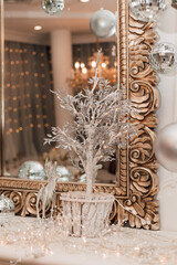 Beautiful golden mirror on the bedside table with Christmas decorations