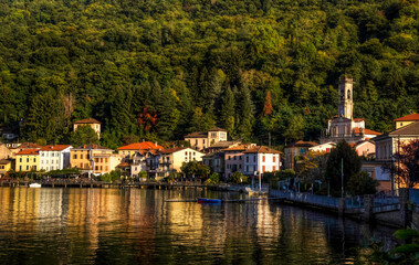 Fototapeta na wymiar Landscape view of Porto Ceresio with evening light and water reflection
