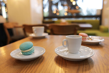 Cup of hot espresso and dessert on table in cafe