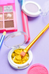 Makeup brush and eyeshadows on color background, closeup