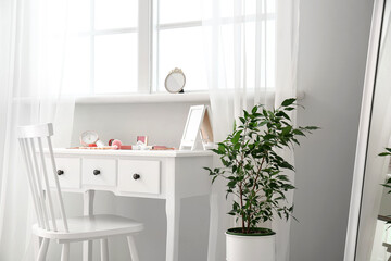 Makeup artist's workplace with decorative cosmetics near light wall in room