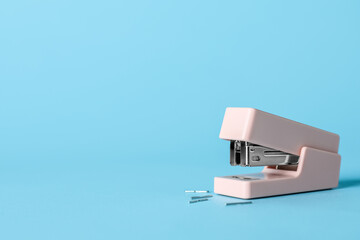 Stapler with staples on color background