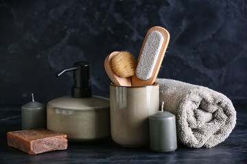 Different bath supplies with candles on dark background