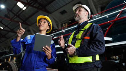 Fototapeta premium Group of apprentices with instructor at railway engineering facility. Teacher talking to apprentices at railway engineering facility
