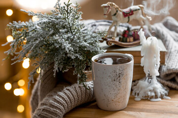 A Christmas card with a vintage horse, candles and a mug of hot coffee on the background of a...