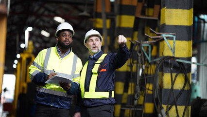 Portrait of engineer and apprentice in workshop of railway engineering facility