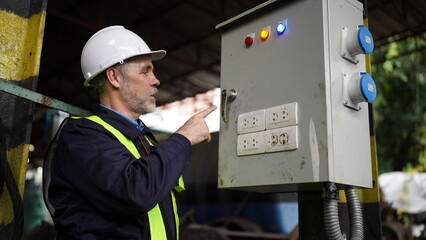 Engineers working at Factory in powerplant and maintenance check on electric control box in factory.