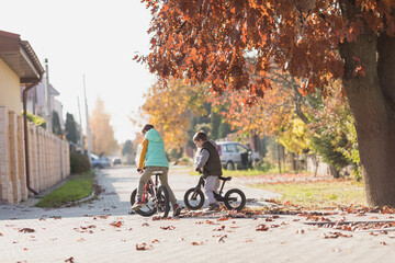 Kids ride on a balance bike and bicycles
