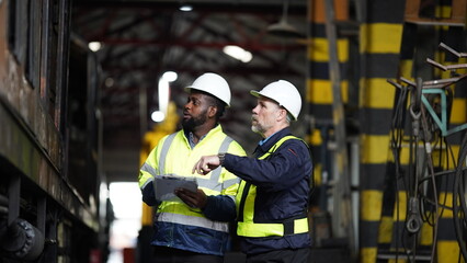 Portrait of engineer and apprentice in workshop of railway engineering facility
