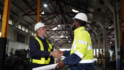 Engineers in discussion in machine maintenance in factory. Group of Industrial Engineers with Blueprint against trains and machinaries industry background. Studying Blueprint with Superior