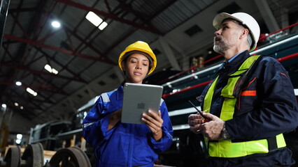 Group of apprentices with instructor at railway engineering facility. Teacher talking to apprentices at railway engineering facility