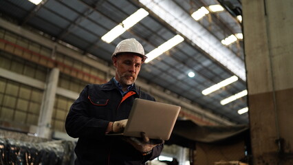 Factory engineer or foreman worker maintaining check equipment parts in factory.