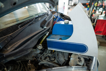 Automated change of brake fluid in a car service. Car bonnet.