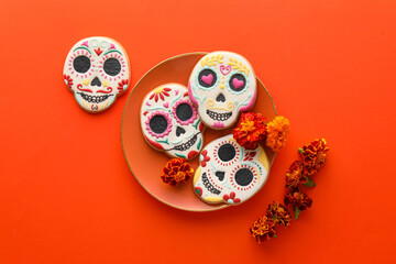 Plate with skull shaped cookies and flowers on red background. El Dia de Muertos