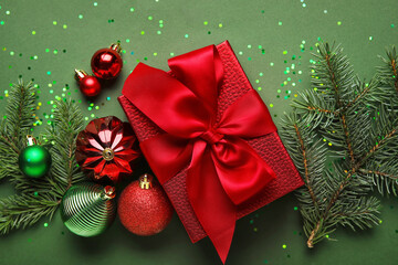 Composition with Christmas gift, decorations and fir branches on color background, closeup