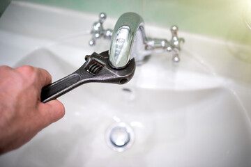 Unscrewing the filter mesh on the faucet in the bathroom with a wrench. Installation of a...