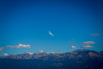 Le Sappey en Chartreuse 10 2022 small glider type recreational aircraft flying in a beautiful blue sky with a view of the mountains