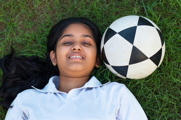 female soccer relaxing lying on the grass tired from practice