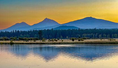 The Three Sisters mountains reflected at sunset in Lake Thalarope on Black Butte Ranch near Sisters Oregon