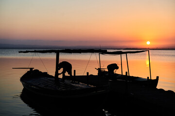 Fishermen working on their boats at sunset in Albufera lake in Valencia