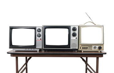 Three vintage televisions on wood table isolated with cut out screens.