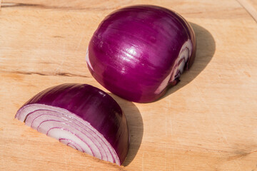 Fresh red onion and cut in half sliced on wooden board background