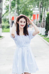 An Asian girl in a white dress playing in the park