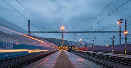 Fototapeta na wymiar Decin station on platform in blue dark cloudy evening