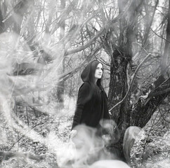 Fototapeta premium Woman in a witch suit in a dense forest