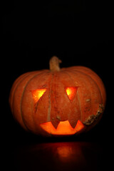 spooky concept - jack-o-lantern with burning eyes on black background