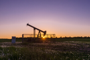Ölpumpe auf einem Feld im Sonnenuntergang