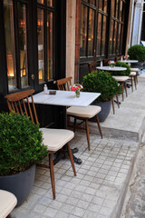 Tables and chairs standing outside near cafeteria on a summer day