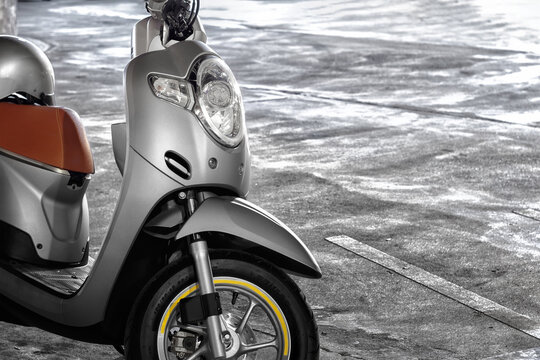 BANGKOK, THAILAND - MARCH 01, 2020: Silver Honda Scoopy i Motor Scooter parks on cement in the Evening.