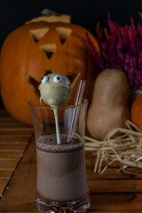 Halloween Getränk mit Geist Kürbisse im Hintergrund und etwas gefärbtes Heidekraut. 
