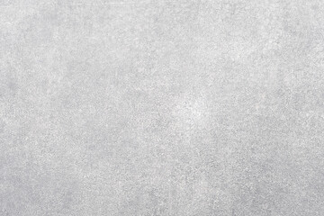 Stony background. Concrete wall. Light surface. Textured grain cementum with small stones covering white paint copy space for text logo.