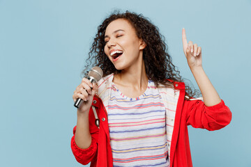 Young singer woman of African American ethnicity 20s she wear red jacket sing song in microphone...