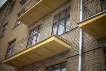 Open balconies. Balconies without glazing in house. Details of old house. Windows in brick wall.