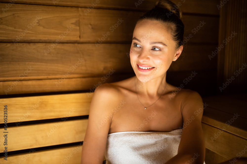 Wall mural woman relaxing in a sauna