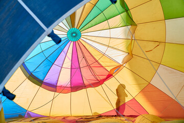 multicolored interior of a hot air balloon while it is in the process of being inflated