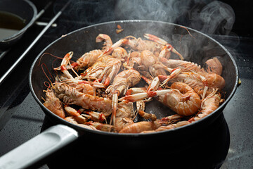 Sartén con cigalas friéndose.