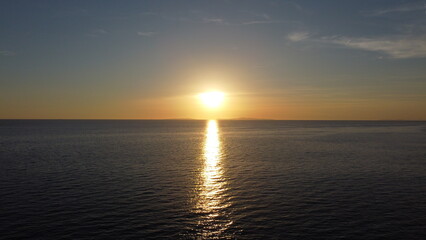 A beautiful sunset that spreads its rays on the calm surface of the ocean