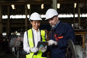 Group of engineer workers working and checking or maintaining machinery, mechanical machine at the industry factory. Team of male and female engineer discussion and working together in the factory