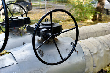 Black iron valves on the water heating main. Valves on heating pipes in the city.