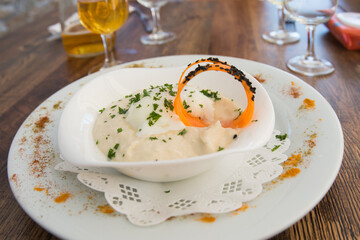 White dish and bowl with sparragous cream and carrot slice