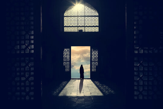 Silhouette of a Muslim woman in a hijab on the background of traditional architecture and sunset. Iran.