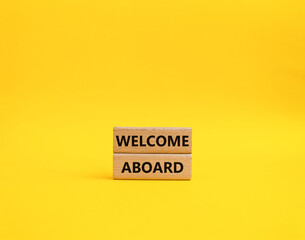 Welcome aboard symbol. Concept word Welcome aboard on wooden blocks. Beautiful yellow background. Business and Welcome aboard concept. Copy space