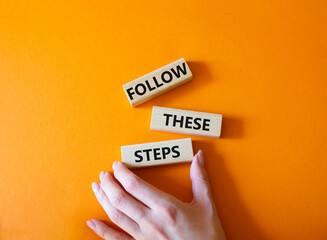 Follow these steps symbol. Wooden blocks with words Follow these steps. Beautiful orange...