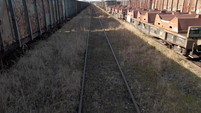 Flying between old rusted wagon trains in an abandoned train deposit