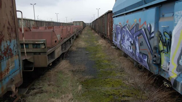 Flying between old rusted wagon trains in an abandoned train deposit