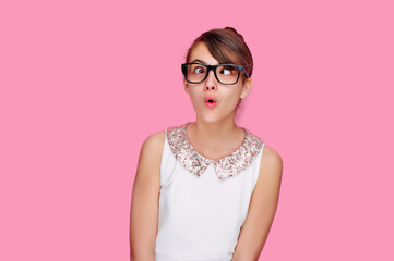 Brunette teen girl in a pink studio gets crossed eyes of dizziness